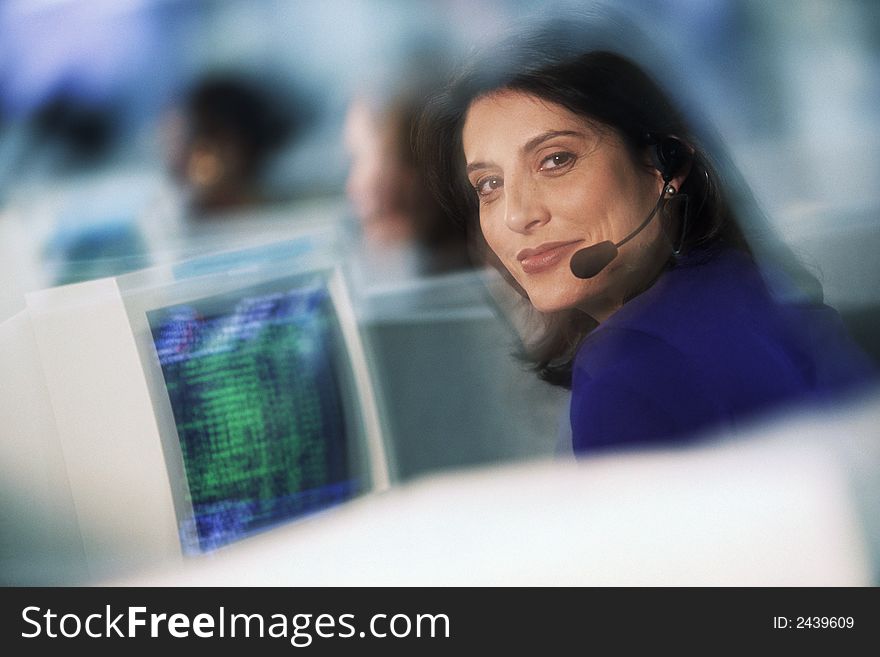 Businesswoman with telephone headset at computer. Businesswoman with telephone headset at computer