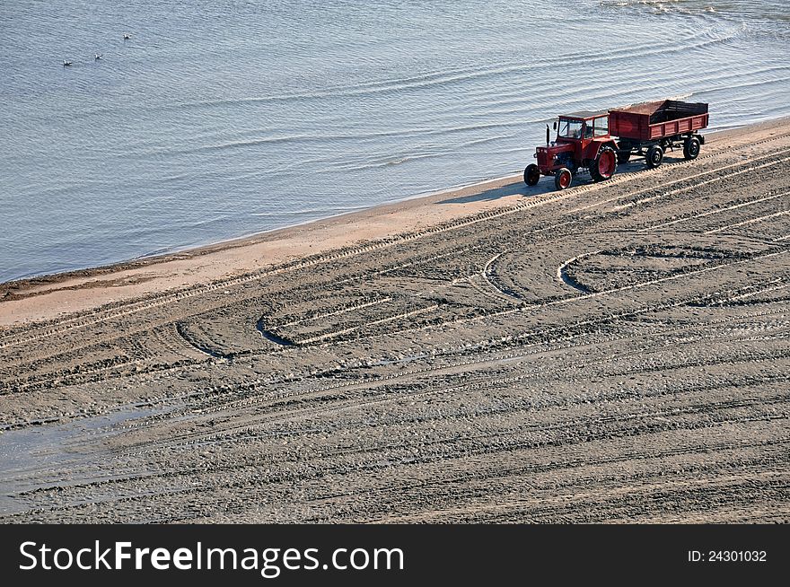 Tractor on the beach and Sunrise over the Black Sea at Mamaia resort near Constanta city in Romania. Tractor on the beach and Sunrise over the Black Sea at Mamaia resort near Constanta city in Romania