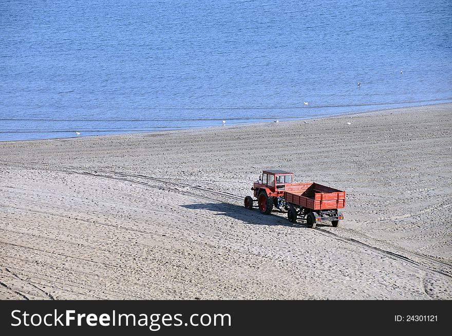 Tractor on the beach and Sunrise over the Black Sea at Mamaia resort near Constanta city in Romania. Tractor on the beach and Sunrise over the Black Sea at Mamaia resort near Constanta city in Romania