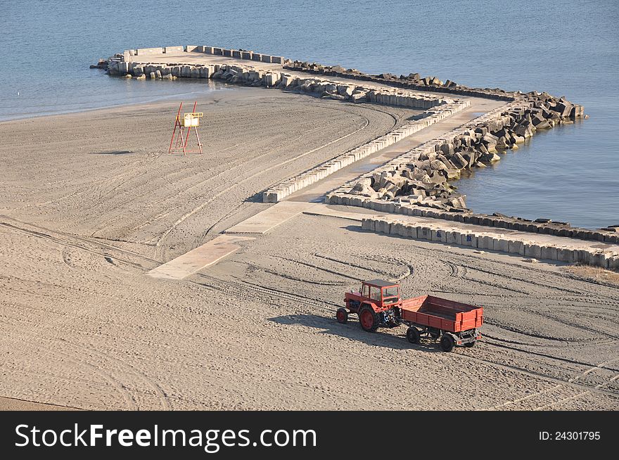 Tractor on the beach and Sunrise over the Black Sea at Mamaia resort near Constanta city in Romania. Tractor on the beach and Sunrise over the Black Sea at Mamaia resort near Constanta city in Romania