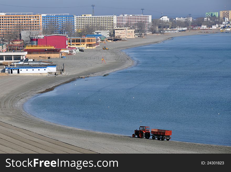 Tractor on the beach and Sunrise over the Black Sea at Mamaia resort near Constanta city in Romania. Tractor on the beach and Sunrise over the Black Sea at Mamaia resort near Constanta city in Romania