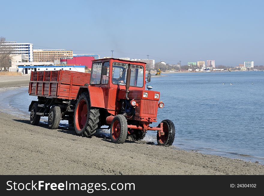 Tractor on the beach and Sunrise over the Black Sea at Mamaia resort near Constanta city in Romania. Tractor on the beach and Sunrise over the Black Sea at Mamaia resort near Constanta city in Romania