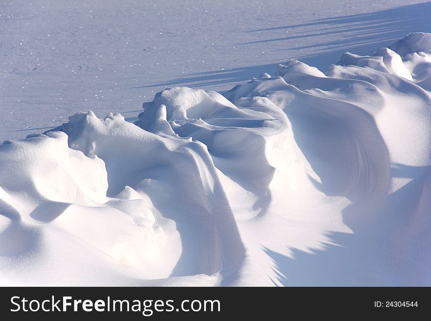 Big snowdrifts in the field shined with a bright sun. Big snowdrifts in the field shined with a bright sun.