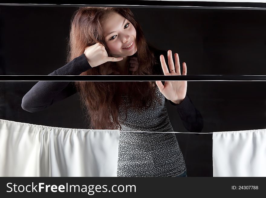 Young beautiful girl in the train window is goodbay on a dark background. Young beautiful girl in the train window is goodbay on a dark background