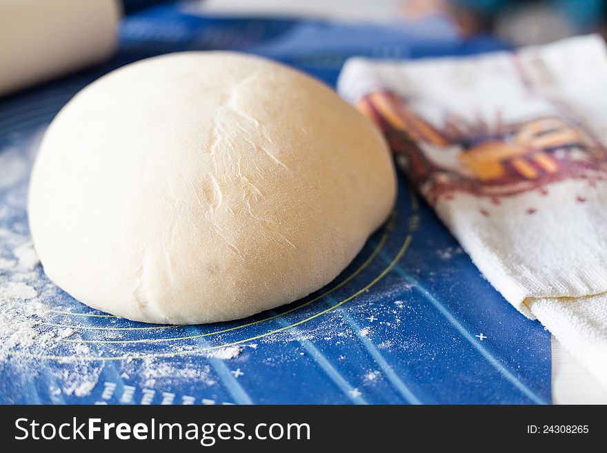 Photo of dough on wooden board.