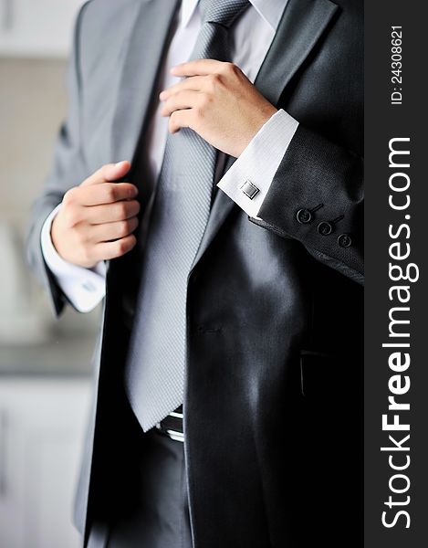 Groom getting ready holding a tie