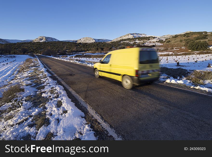 Circulating van road maintenance speeding along a straight road