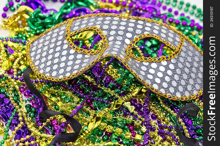 Seqioned Mardi Gras Masquerade Mask on background of Mardi Gras beads