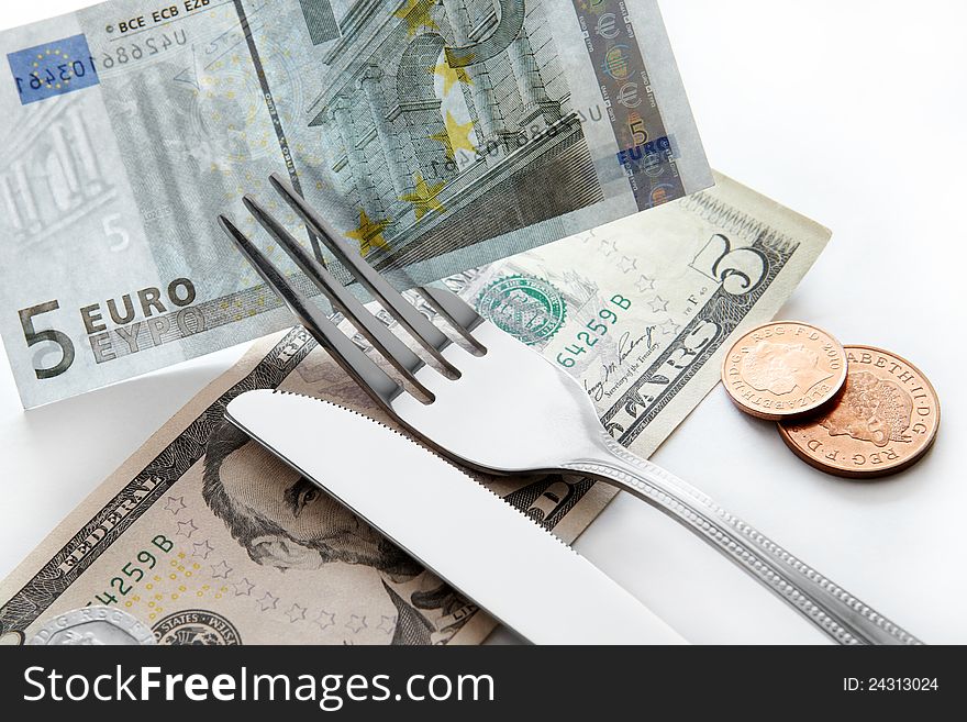 Business concept. Banknotes of dollars, euros with a fork and knife.