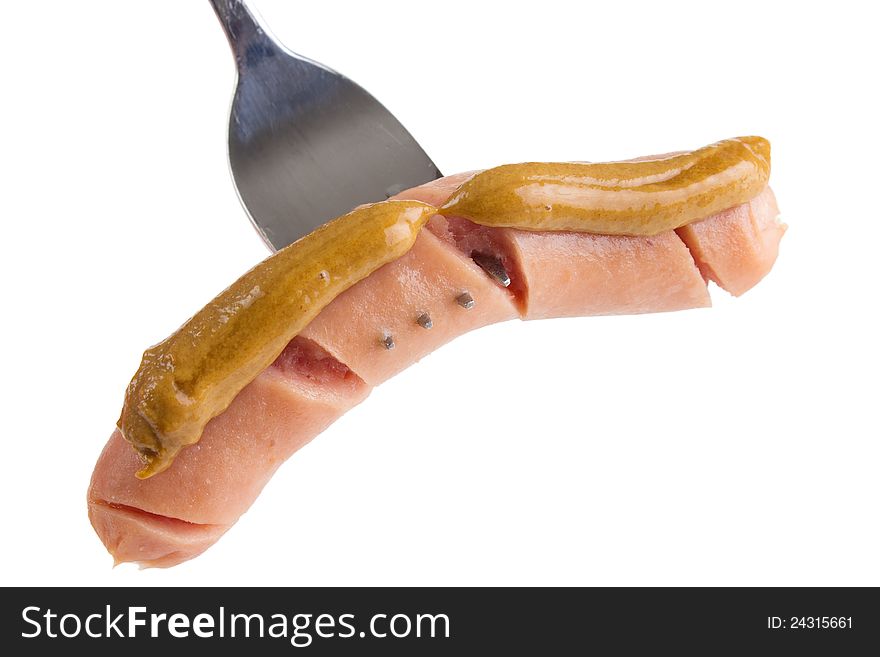 Wiener with mustard on the fork, isolated on white