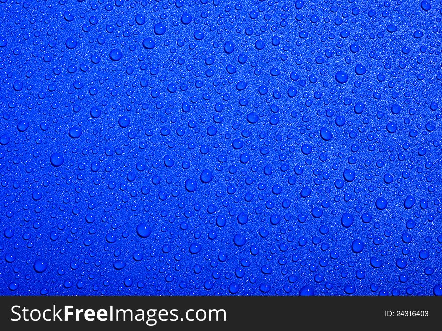 Crystal clear water drops over blue background
