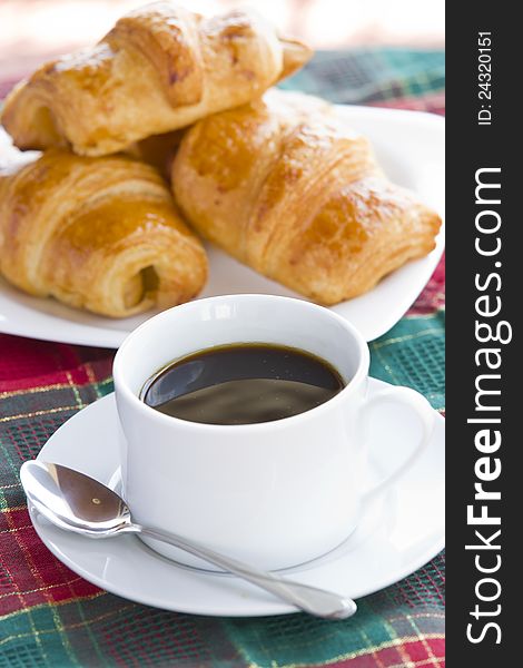 Breakfast with black coffee and croissants