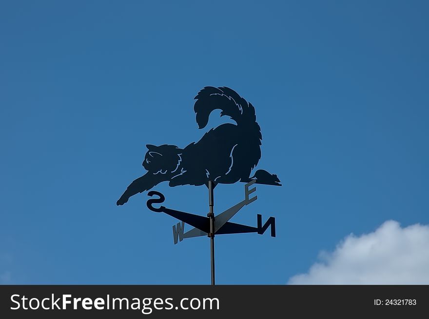 Weathervane with blue sky in the form of a cat and mouse. Weathervane with blue sky in the form of a cat and mouse