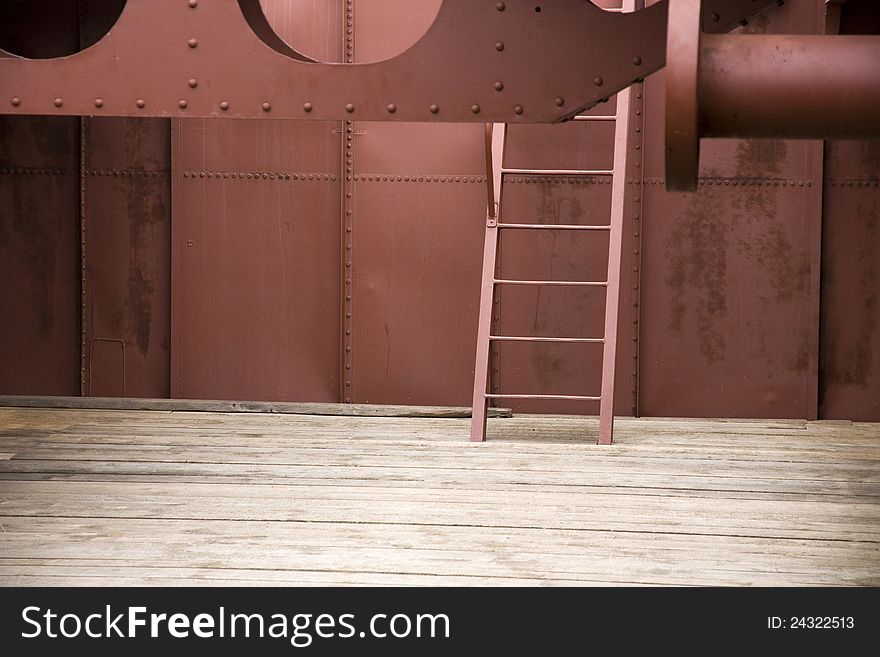 Red metal ladder inside the ship, metal structure with wooden floor. Red metal ladder inside the ship, metal structure with wooden floor