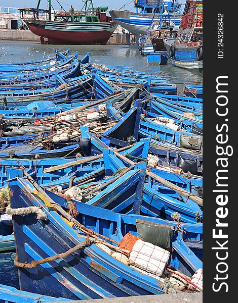 Rows of blue wooden fishing boats in port