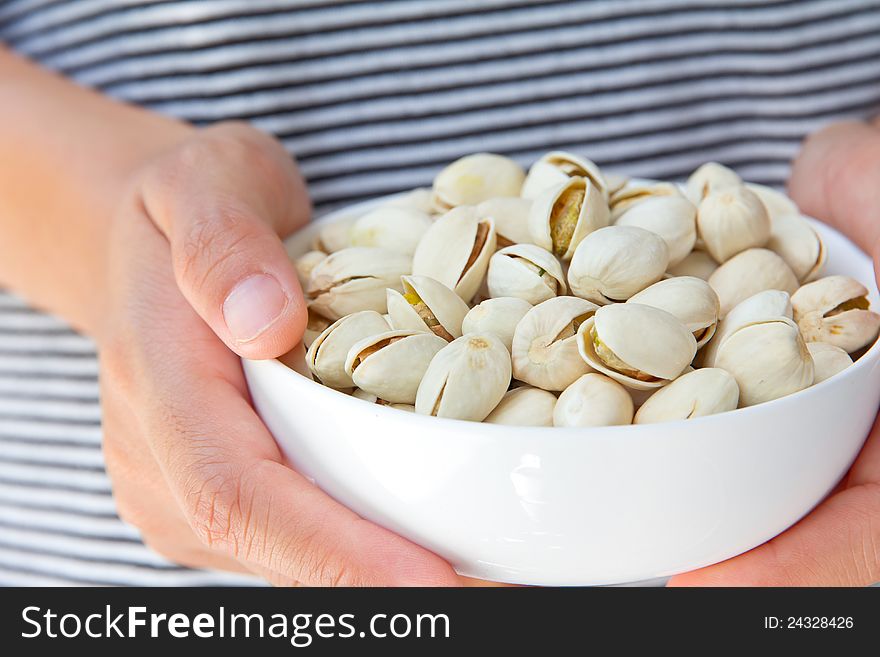 Close up image of hand holding pistachios