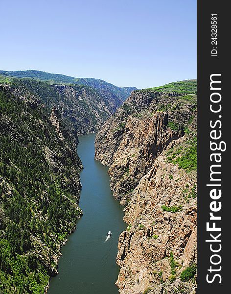 A boat travels up the Gunnison Gorge in the Colorado Mountains. A boat travels up the Gunnison Gorge in the Colorado Mountains