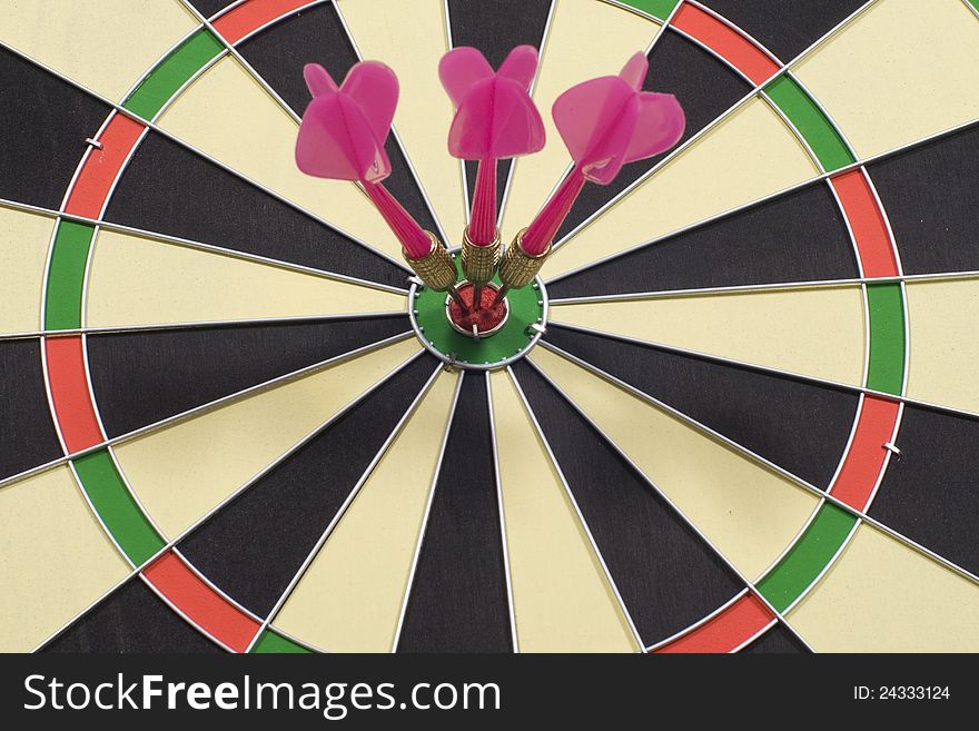 Three darts hitting a target on circular dart board. Three darts hitting a target on circular dart board