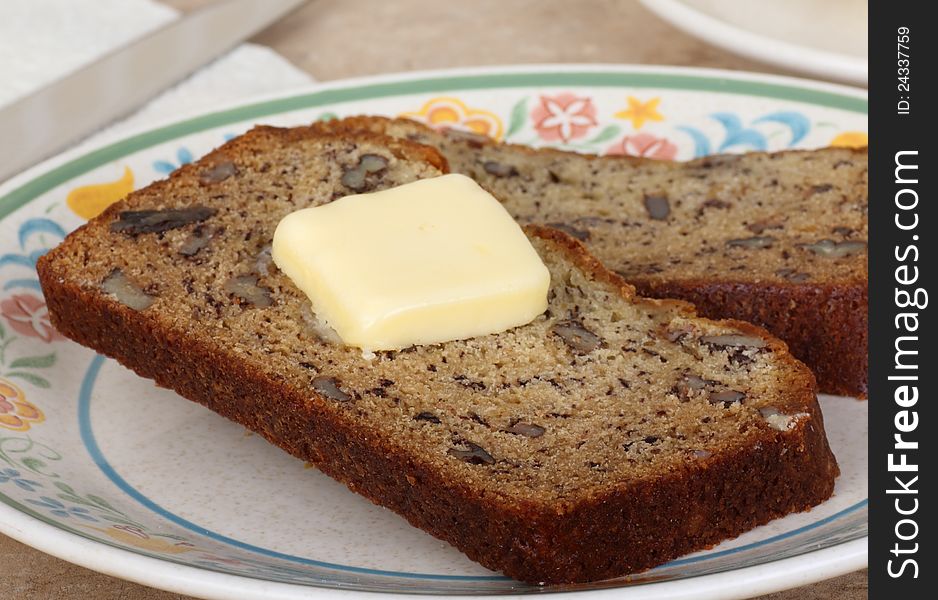 Slices of nut bread with butter on a plate. Slices of nut bread with butter on a plate