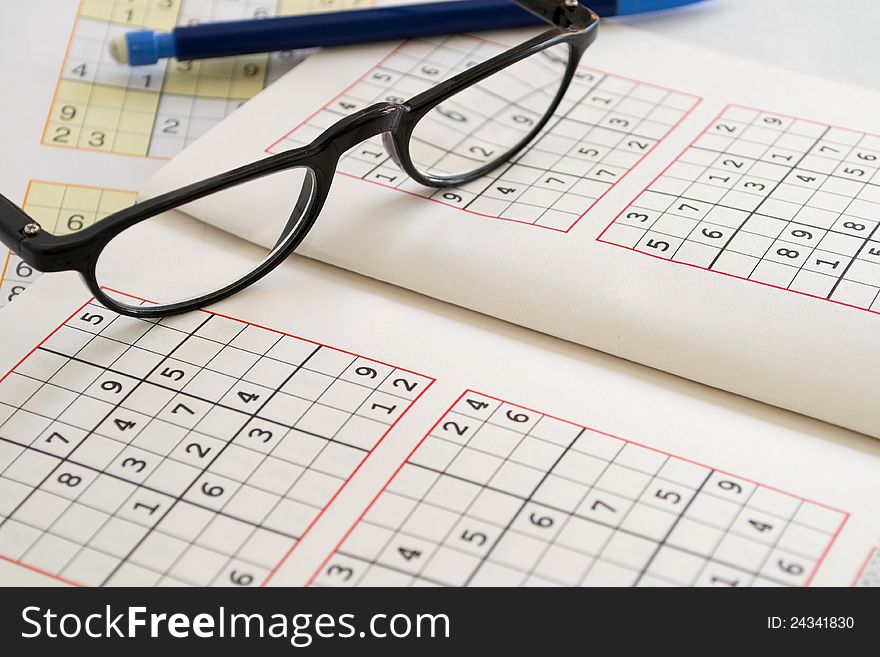 Relax with Sudoku, pencil with eraser rubber and reading glasses