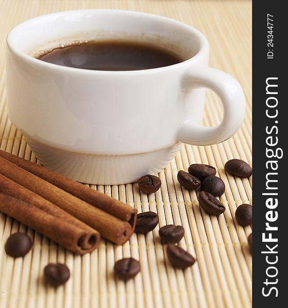 Cup of coffee, cinnamon sticks and coffee beans