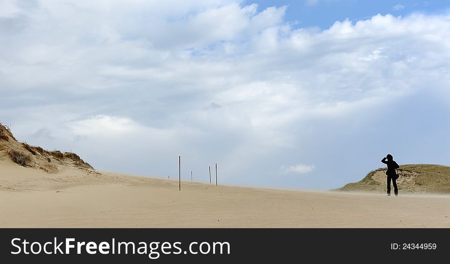 A man walks in the dunes