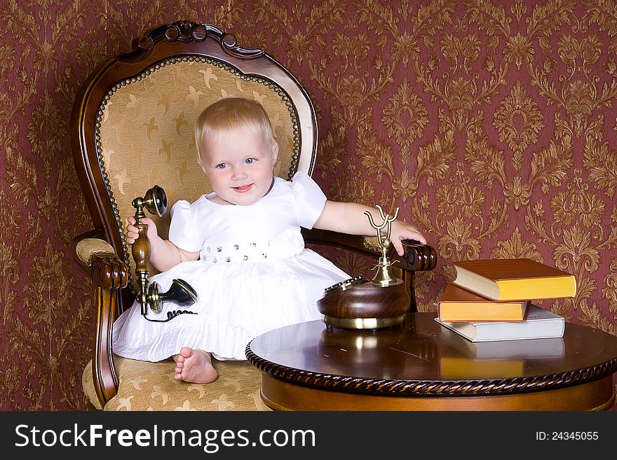 Laughing girl with the phone in his hand sitting on an old chair