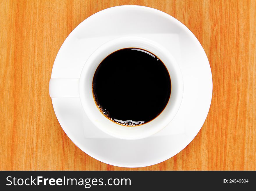 Black coffee cup on wood background, view top. Black coffee cup on wood background, view top