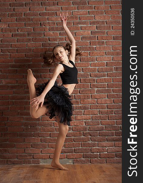 Girl in black skirt  dancing near brick wall in studio. Girl in black skirt  dancing near brick wall in studio