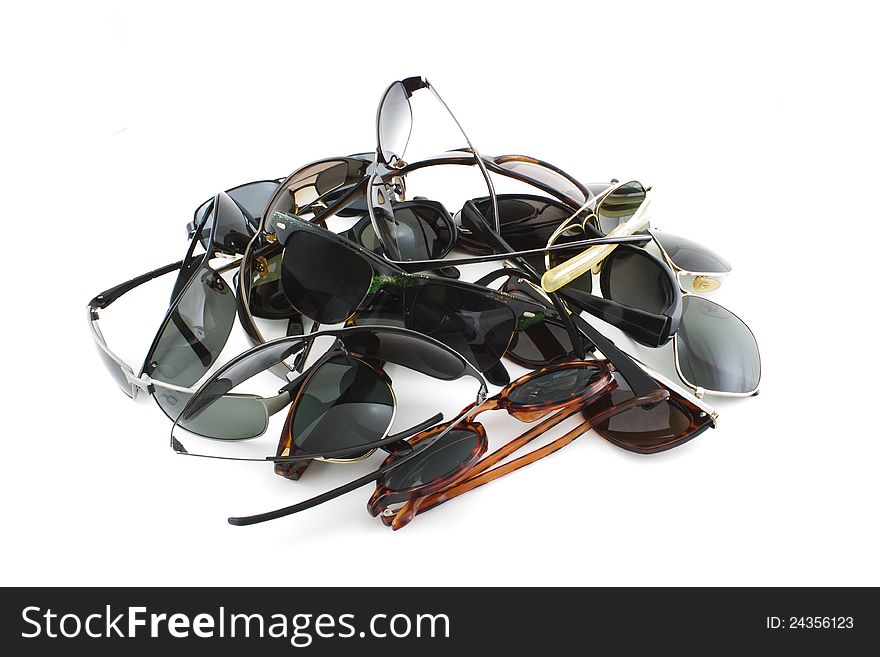 Several pile up sunglasses on white background
