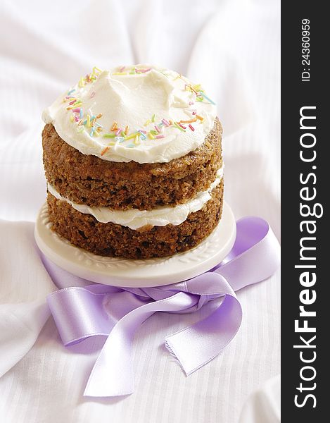 Fresh delicious carrot cake decorated with colorful confetti and ribbon