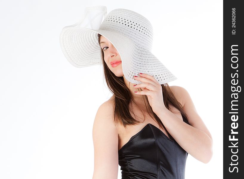 A portrait of a gorgeous young woman, peeking out from under a white hat and smiling coyly at the viewer. A portrait of a gorgeous young woman, peeking out from under a white hat and smiling coyly at the viewer