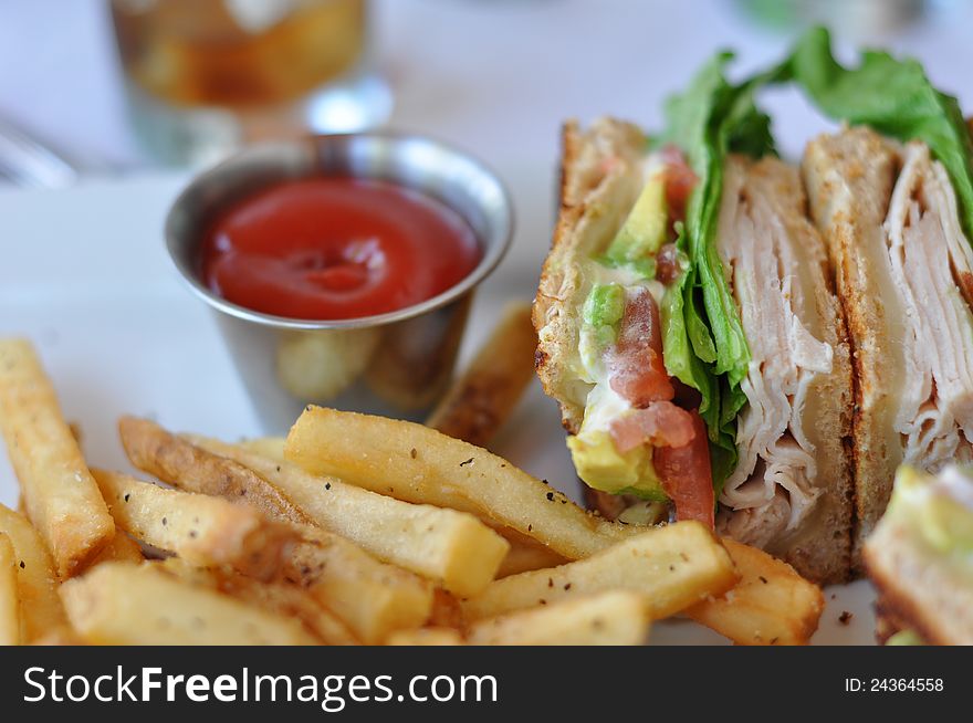 Turkey Club Sandwich with Avocado served with a side order of French Fries