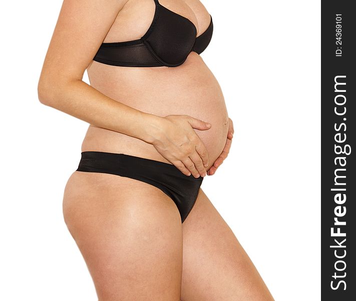Pregnant woman in black underwear holding her belly on a white background. Pregnant woman in black underwear holding her belly on a white background