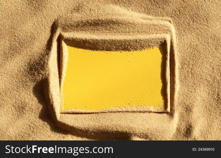 Closeup of blank yellow paper sheet on sand surface. Closeup of blank yellow paper sheet on sand surface