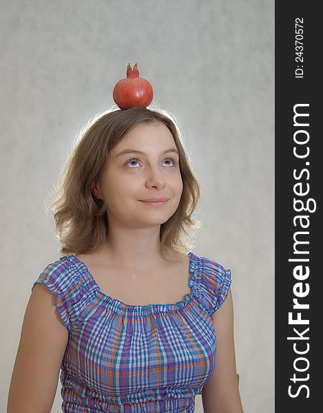 Girl holding pomegranate on her head. Girl holding pomegranate on her head