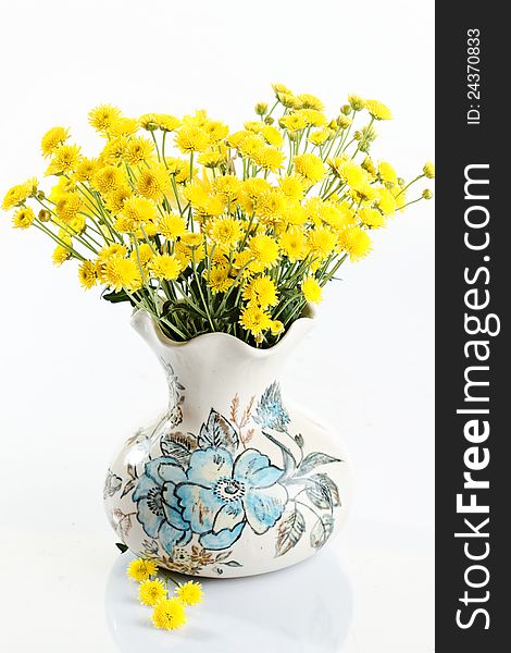 Yellow small flowers in a vintage vase on white. Yellow small flowers in a vintage vase on white