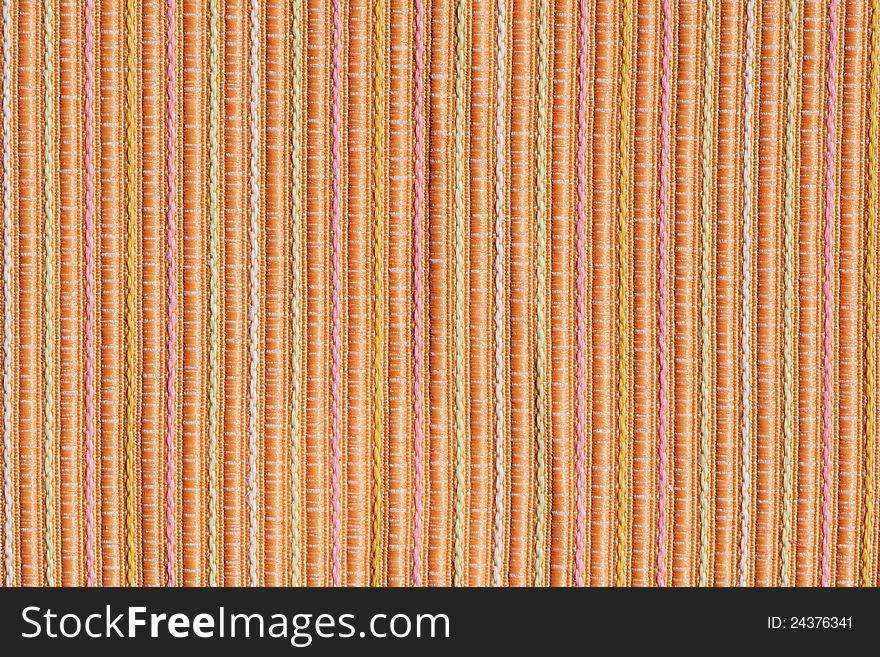 Background of stripy orange and pastel yellow and pink colours fabric. Background of stripy orange and pastel yellow and pink colours fabric