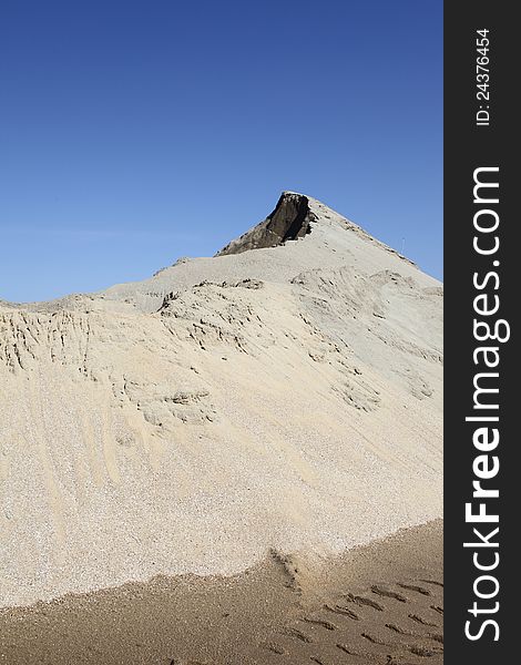 Grey sand mound and clear blue sky