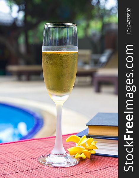Wine glasses and book at the pool. Relaxing scene. Wine glasses and book at the pool. Relaxing scene