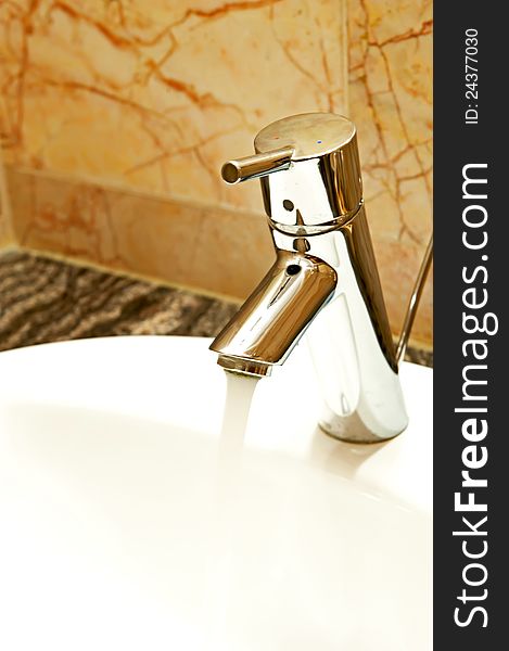 Closeup of a chrome faucet and porcelain sink.