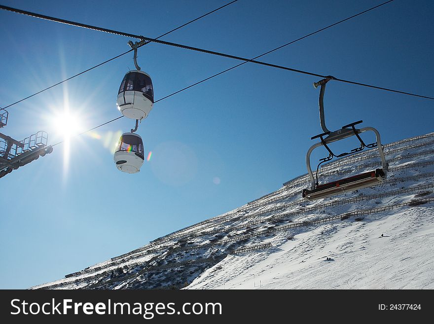 Ski lifts on background of slope with protection from avalanches in sunny day. Ski lifts on background of slope with protection from avalanches in sunny day