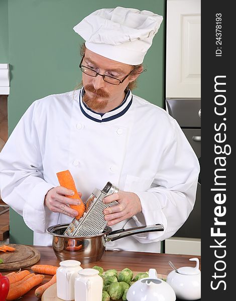 Young chef with carrot, preparing lunch in kitchen. Young chef with carrot, preparing lunch in kitchen