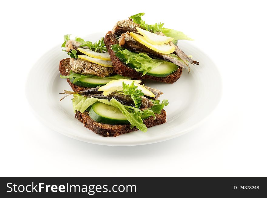 Smoked sardines sandwich with cucumber and whole wheat bread on white plate