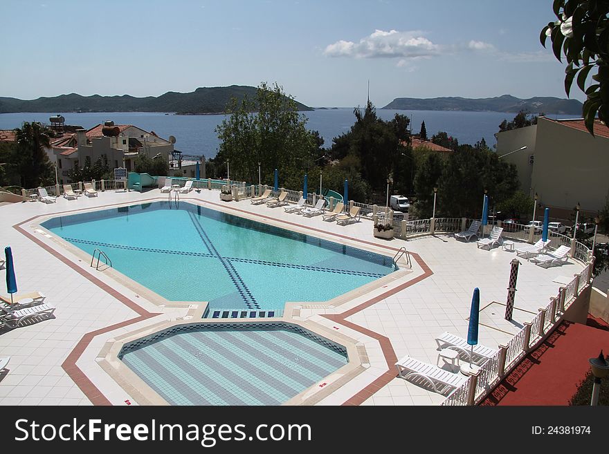 An empty hotel pool in the town of Kas shows the islands in the background, including the Greek Island of Meis. An empty hotel pool in the town of Kas shows the islands in the background, including the Greek Island of Meis