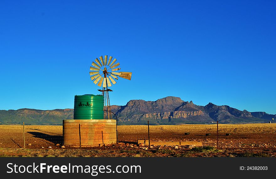 Landscape with water pump windmill on cattle farm westerncape south africa