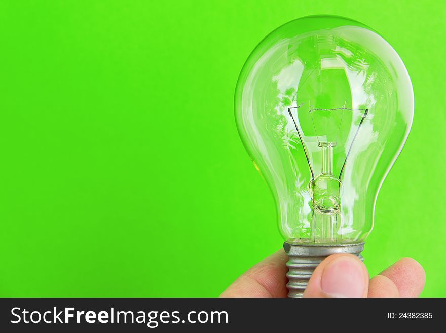 Light blub in hand with green background, eco energy concept