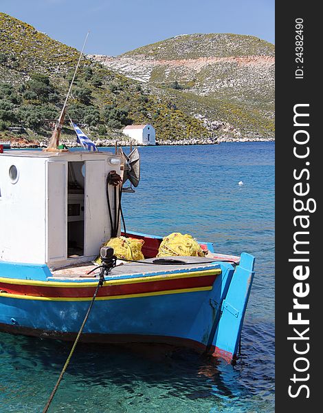 A fishing boat in the harbour of Meis Greece, with a small church at the waters edge. A fishing boat in the harbour of Meis Greece, with a small church at the waters edge.