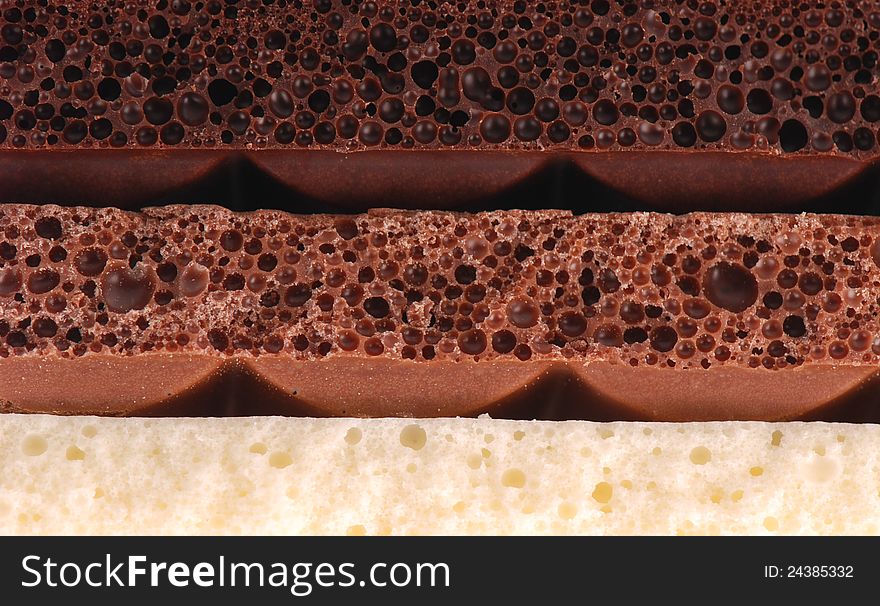 Background of black, brown and milk white blocks of Porous chocolate