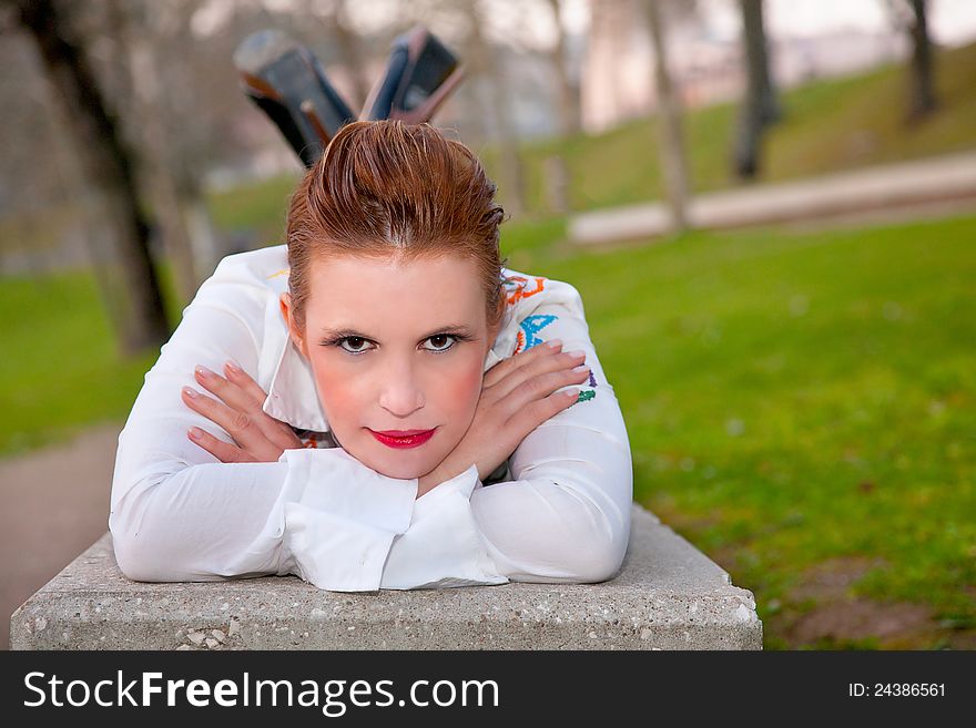 Beautiful middle-aged woman, lying on a garden bench, in outside